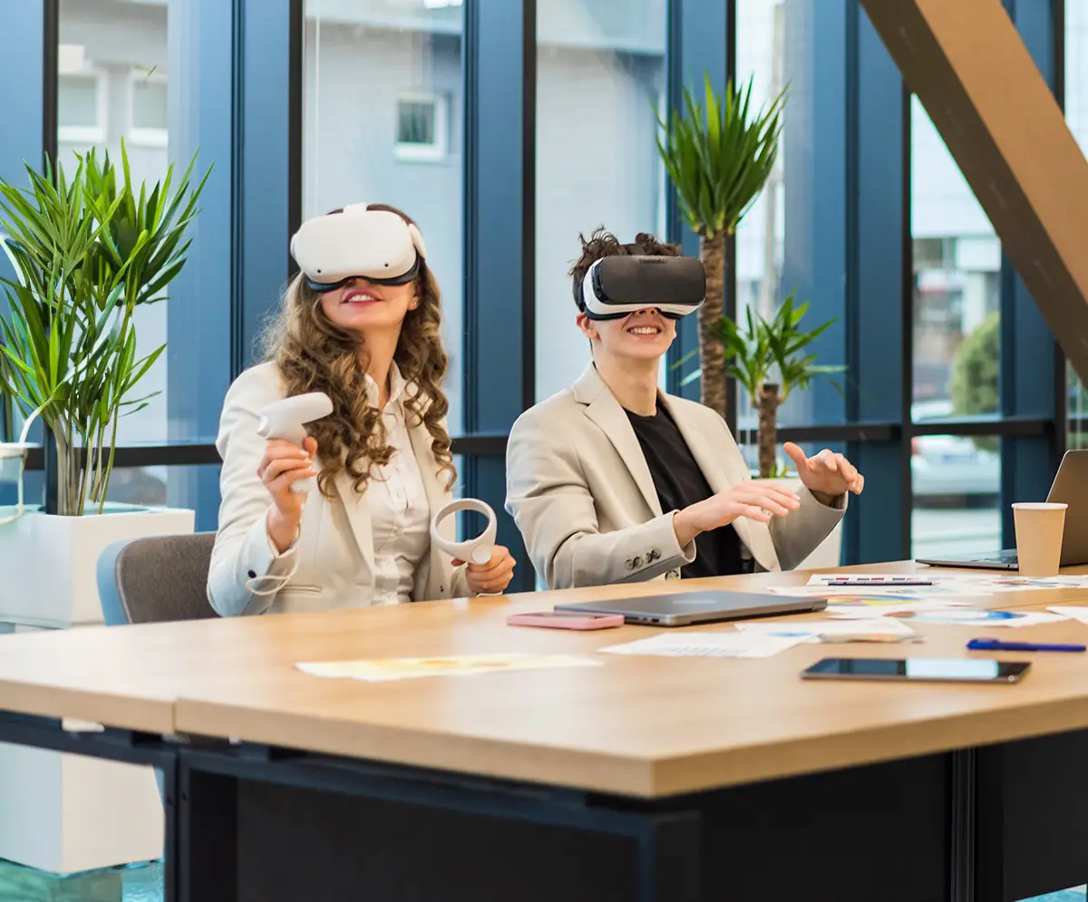 Two corporate office workers, a male and a female, wearing virtual reality masks in an office during a meeting, viewing a production created for them.